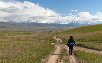 Man on way in steppe and Pamir mountains - Kyrgyzstan